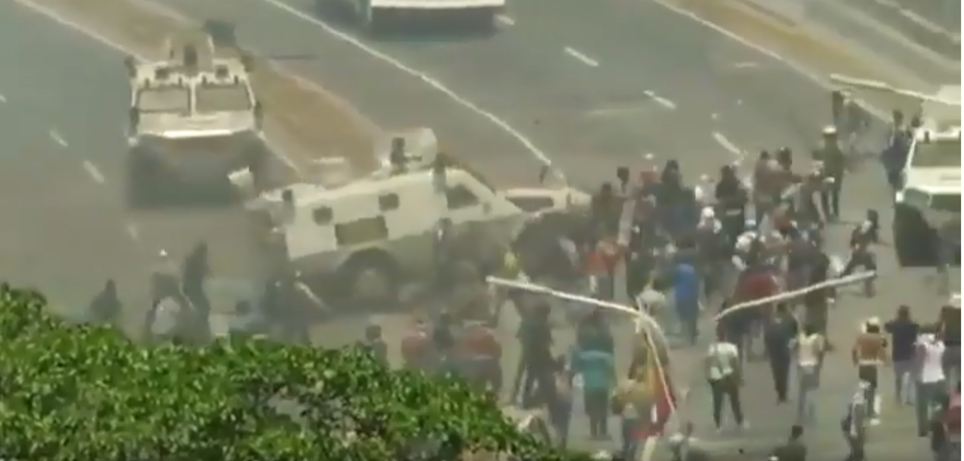 omento em que tanques da Guarda Nacional Bolivariana avançam contra manifestantes na Venezeula