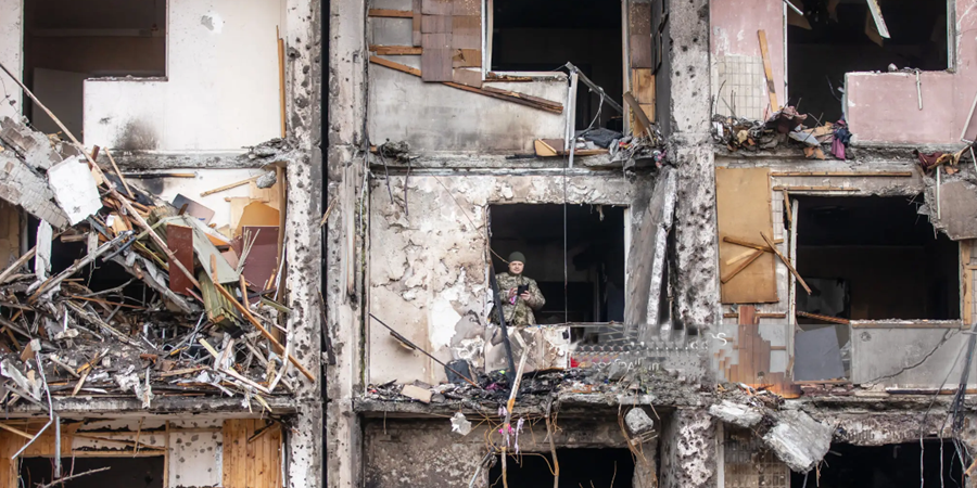 Um soldado ucraniano inspeciona um edifício residencial depois de ter sido danificado após um ataque de bombardeio russo em Kyiv. Mykhaylo Palinchak/SOPA Images/LightRocket via Getty Images